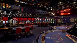 A casino with multiple blackjack tables, slot machines, and a neon sign for the cashier.