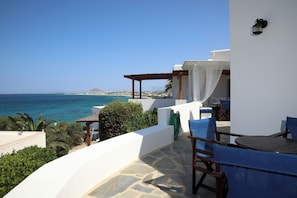 Une terrasse avec vue sur la mer, un sol en pierre et du mobilier d’extérieur.