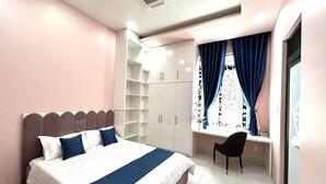 A bedroom with a bed, a desk, and a chair.