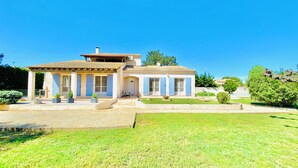 Una casa de dues plantes amb teulada d'rajola, un porxo i un jardí ben cuidat.