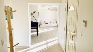 Passadís que condueix a un dormitori amb un piano, un llit i una porta amb tancament de clau electrònica.