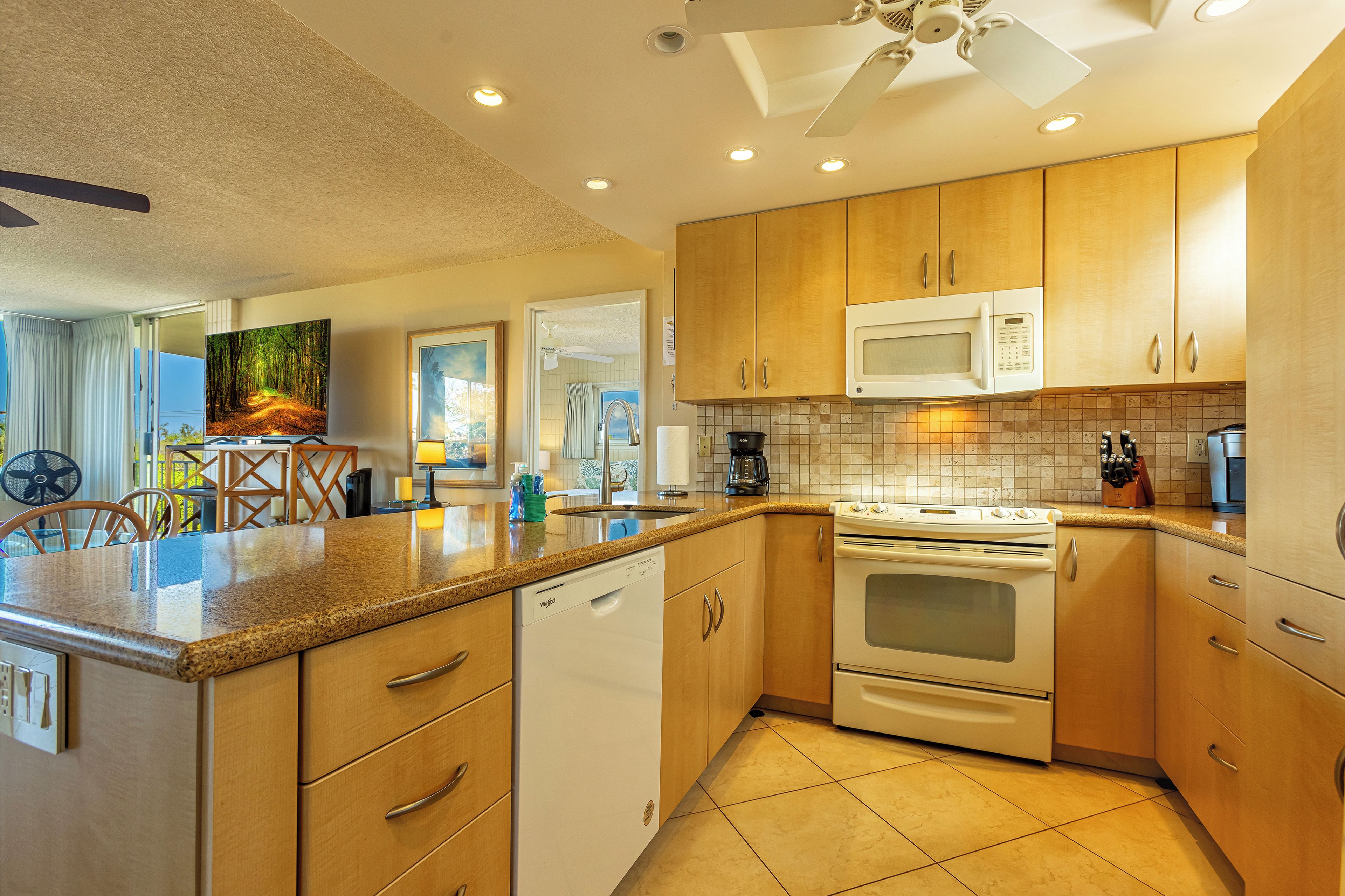 A modern kitchen with wooden cabinets, a microwave, an oven, and a dishwasher.