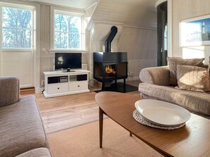 A cozy living room with a fireplace, a television, and comfortable seating.