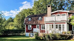 A two-story house with a red exterior, white trim, and a chimney. - 4 Star Holiday Home in Farjestaden (Farjestaden)