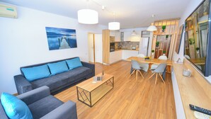 Un salon moderne avec un canapé, une table basse et un coin repas.