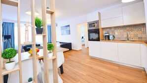 Un appartement moderne comprenant une cuisine, un coin repas et un salon.