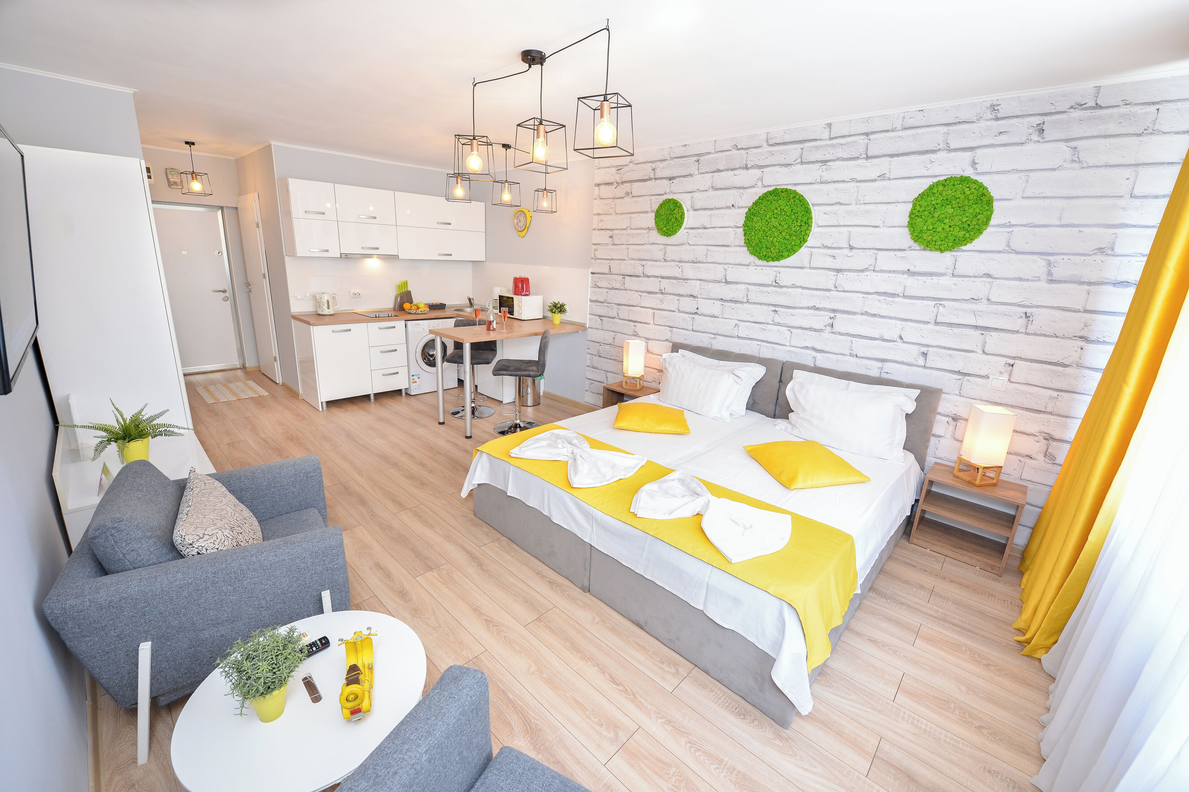 Une chambre d’hôtel moderne équipée d’un lit, d’un canapé, d’un coin repas et d’une cuisine.