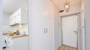 A modern kitchen with white cabinetry, a wooden countertop, and a washing machine. - Candy Studio - Cismigiu Gardens - Quiet Room - Open Kitchen -Smart Tv (București)