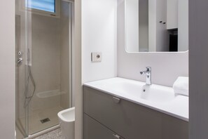 Standaard studio | Badkamer | Een douche, een haardroger, handdoeken, zeep
