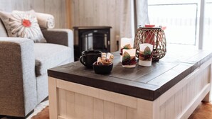 A cozy living room with a wooden coffee table, a sofa, and a small side table. - Brand New Quiet Country Cabin (Rock View County)