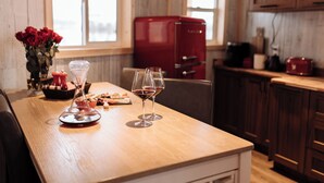 A wooden table with two wine glasses and a vase of red roses. - Brand New Quiet Country Cabin (Rock View County)