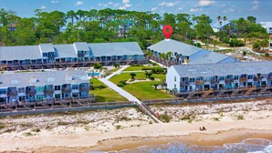 A beachfront hotel with multiple buildings, a boardwalk, and a beach.