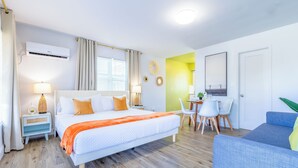 Una habitación de hotel moderna con una cama grande, un escritorio y una zona de estar.