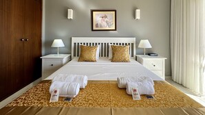 A hotel room with a bed, two bedside tables, a nightstand, a wardrobe, a framed picture on the wall, and a window with curtains. - Albufeira Central 8 by Homing (Albufeira)