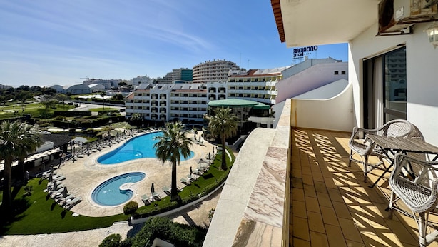 A hotel with a pool, outdoor seating, and a view of the surrounding area. - Albufeira Central 8 by Homing (Albufeira)