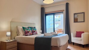 A hotel room with a bed, bedside tables, a chair, a balcony, and a view of the outside. - Armação DE Pêra Ocean Terrace by Homing (Silves)
