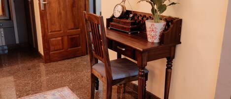A wooden desk with a clock, a potted plant, and a decorative box.