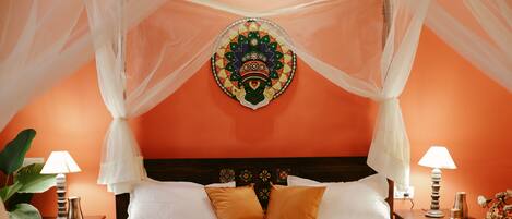 A bed with white linens, two brown pillows, and a decorative headboard.
