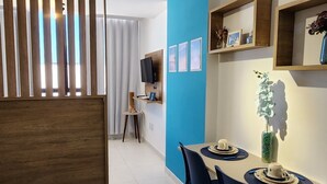 Een moderne eetruimte met een houten scheiding, een blauwe accentmuur en een eettafel met stoelen.
