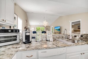 A kitchen with a built-in oven, coffee maker, and paper towel dispenser.