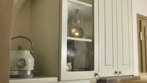 Una cocina con un mueble empotrado, una tetera y un recipiente de vidrio sobre la encimera.