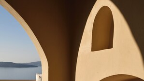 Una habitación con vistas al mar, una mesa redonda y un banco curvo.