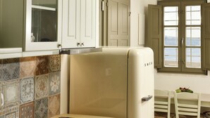 Una cocina con horno empotrado, una mesa de comedor con sillas y una ventana con vistas.