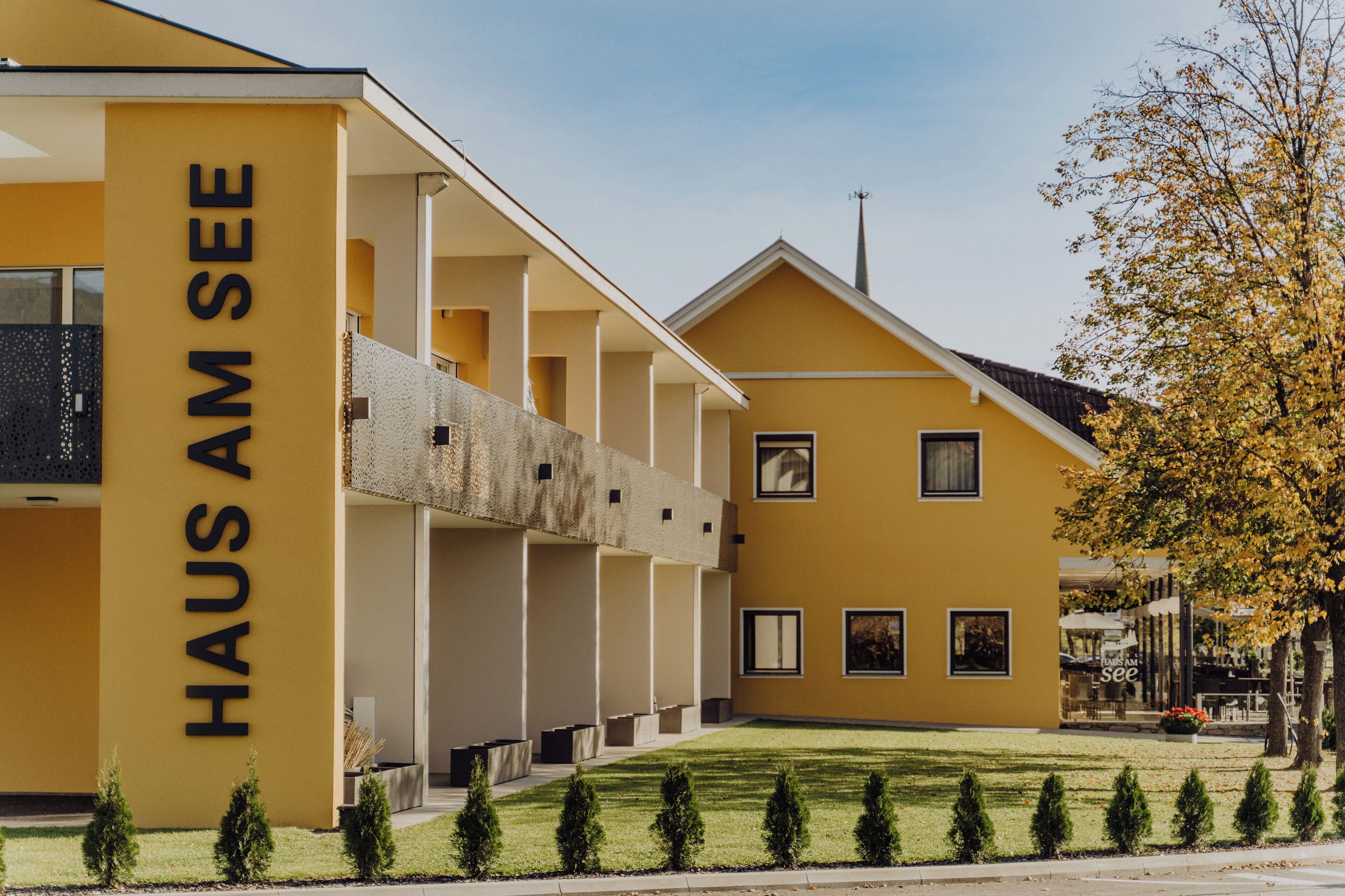 A yellow building with the sign "HAUS AM SEE" on the side.