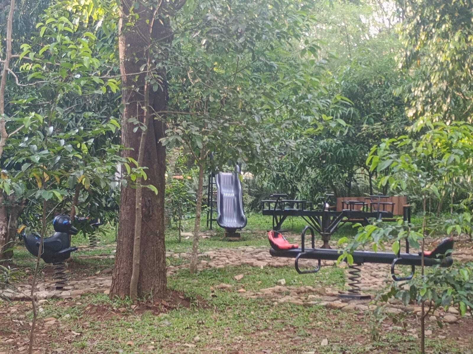 Ein Spielplatz mit Rutsche, Schaukeln und einer Bank.