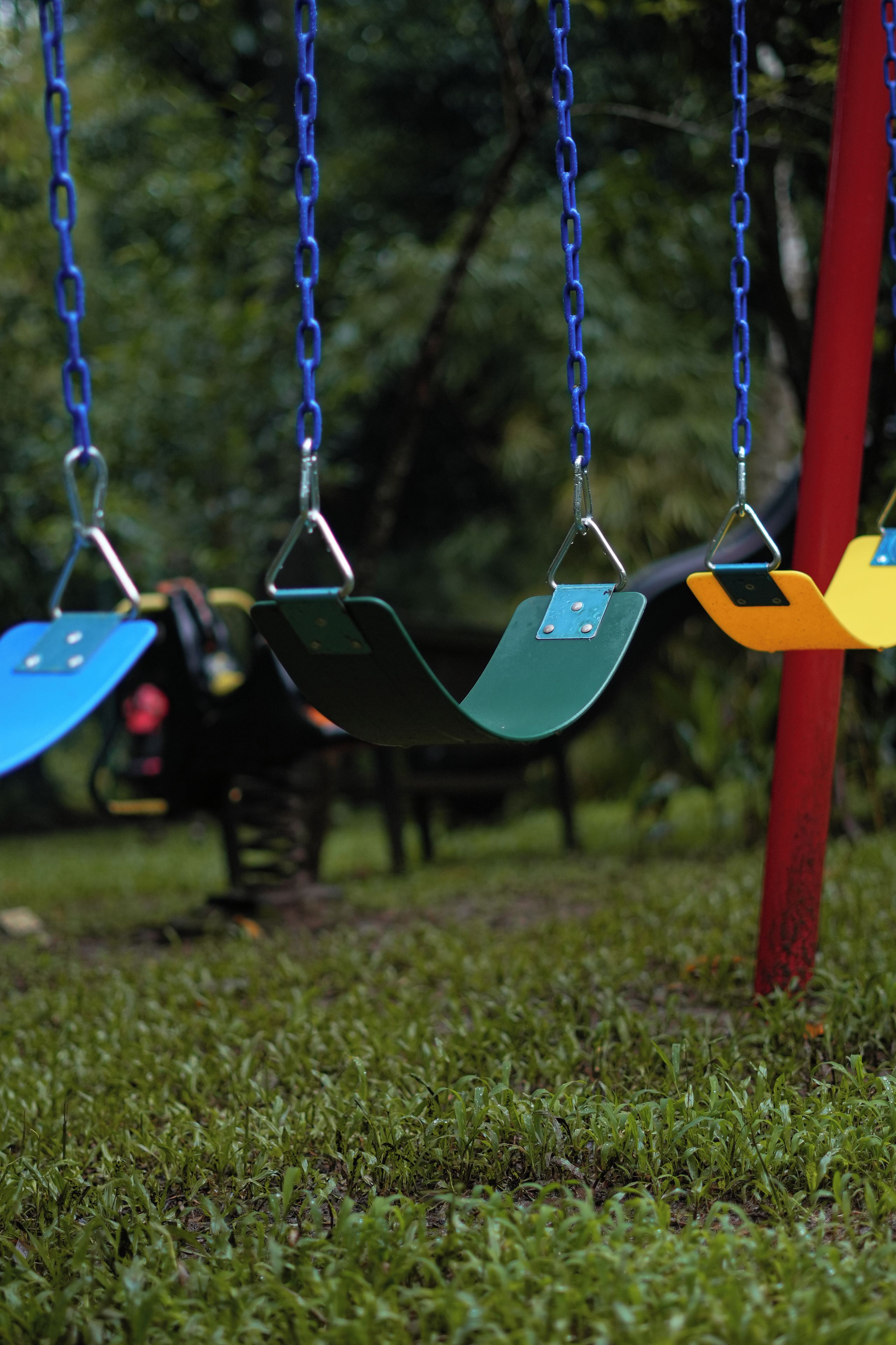 A swing set with multiple swings in different colors.