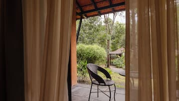 Una habitación con vistas a un área de estar exterior, una silla y un techo con diseño.