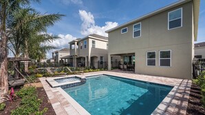 A residential building with a swimming pool, outdoor seating, and a patio area. - Contemporary Disney VacationHome (Kissimmee)