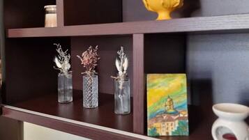 A shelf with three glass vases, a yellow decorative item, and a small painting.