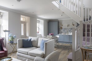 A spacious living room with a sofa, a dining area, and a kitchen.