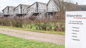 A row of traditional houses with multiple windows and a staircase leading to the upper floors. - 2 Person Holiday Home in Hojer (Højer)