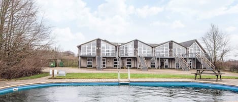 A two-story building with a swimming pool in front.