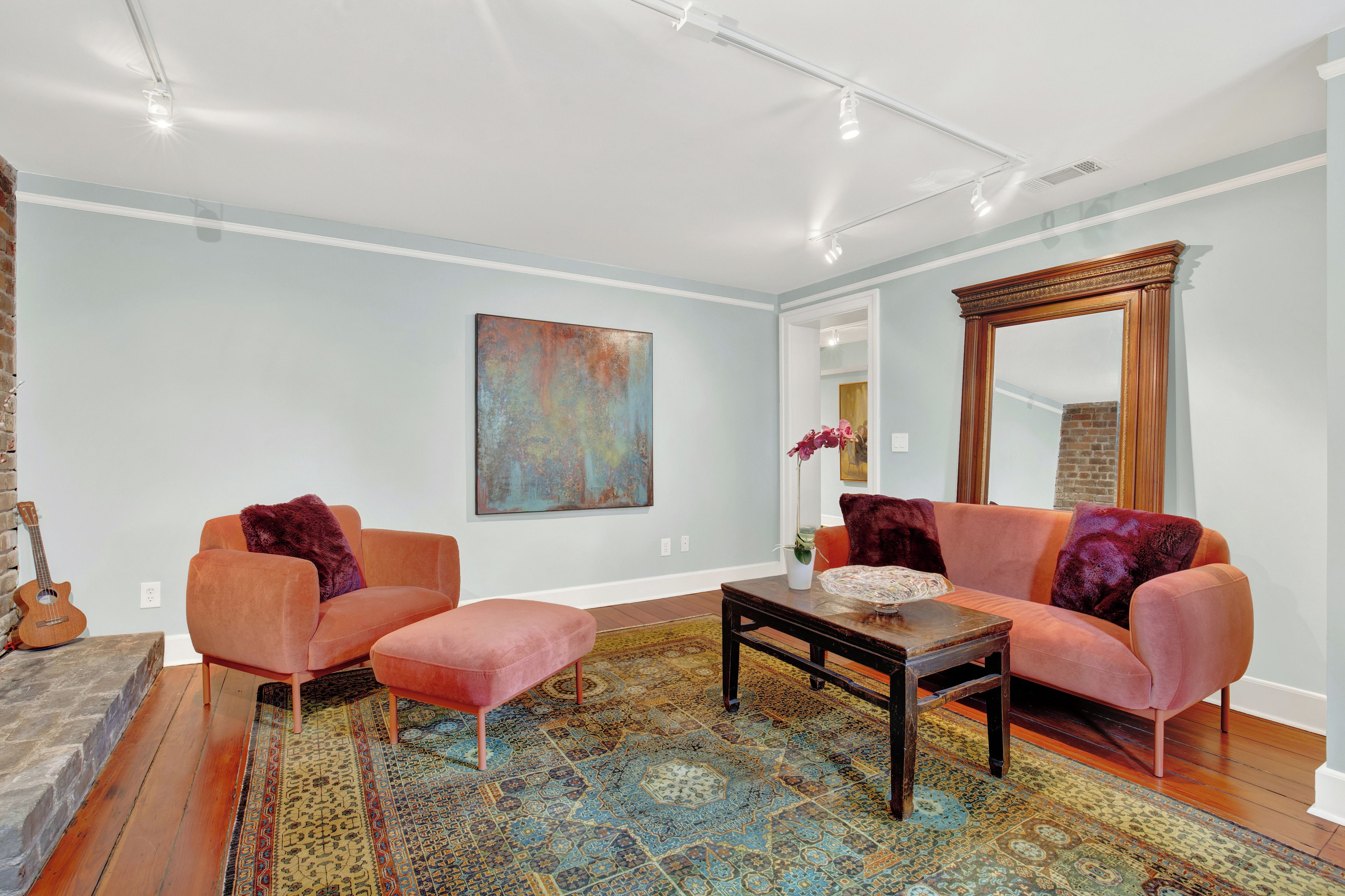 Un salon avec un canapé d’angle, une table basse et un tapis à motifs.