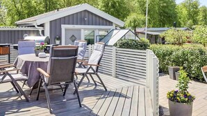 En uteplats med utemöbler, en grill och en svensk flagga.