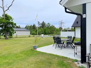 A patio with outdoor furniture, a flagpole, and a building in the background. - 4 Star Holiday Home in Gotlands Tofta (Gotlands Tofta)