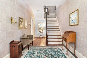 Un escalier avec une rampe en bois et une zone de palier recouverte de moquette.