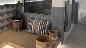 A modern bathroom with a large arched window, a shower area, and a wooden floor. - Agathi Beauty Studios (Rhodes)