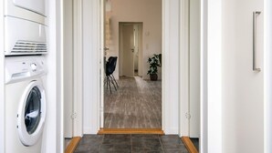 A laundry room with a washing machine, dryer, and stacked drying racks. - 4 Star Holiday Home in Borkop (Borkop)