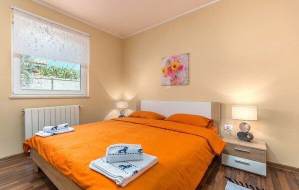 A bedroom with a bed, two bedside tables, a window with a view, and a painting on the wall. - Serene Retreat with Garden View, 2 km from Novigrad City Center and Beach (Novigrad)