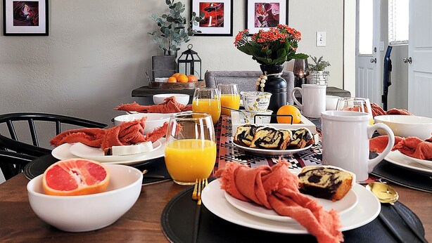 Ein Frühstückstisch mit verschiedenen Speisen, darunter Grapefruit, Orangensaft und Gebäck.
