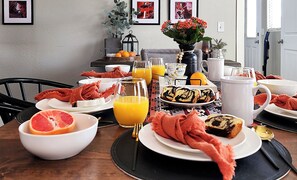 Een ontbijttafel met diverse gerechten, waaronder grapefruits, sinaasappelsap en gebak.