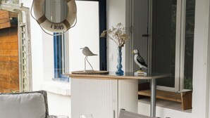 A dining area with a table set for six, a life preserver sign, and a bird figurine on a shelf. - 50 m from the beach, pretty Breton house in the heart of the Pink Granite Coast (Trégastel)