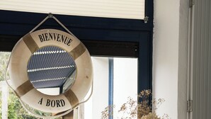 A welcome sign, a vase with dried flowers, a bird figurine, and a lamp on a counter near a window. - 50 m from the beach, pretty Breton house in the heart of the Pink Granite Coast (Trégastel)
