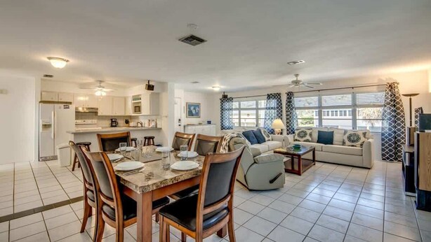 A spacious living area with a dining table, chairs, a sofa, and a TV. - 190 Anchorage Unit A Spacious Unit near Beach (Fort Myers Beach)