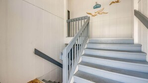 A staircase with a grey railing and white walls. - 190 Anchorage Unit A Spacious Unit near Beach (Fort Myers Beach)