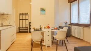 Una cocina compacta con una mesa, sillas y un radiador.